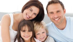 Happy family of four smiling together.